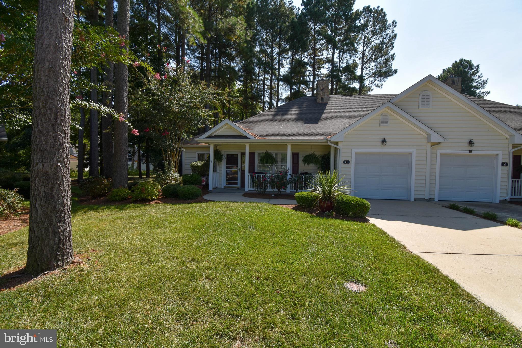 a front view of a house with a yard and trees