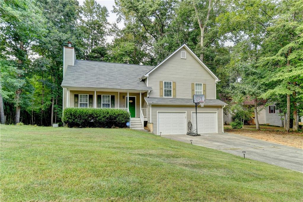 a front view of a house with a yard and trees