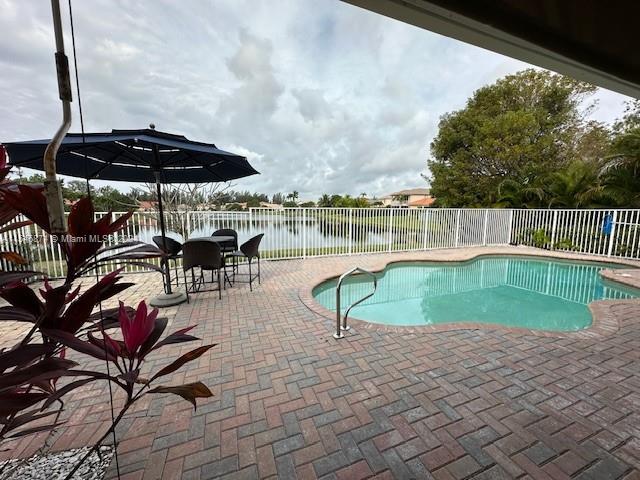 a view of a swimming pool with a patio and a yard