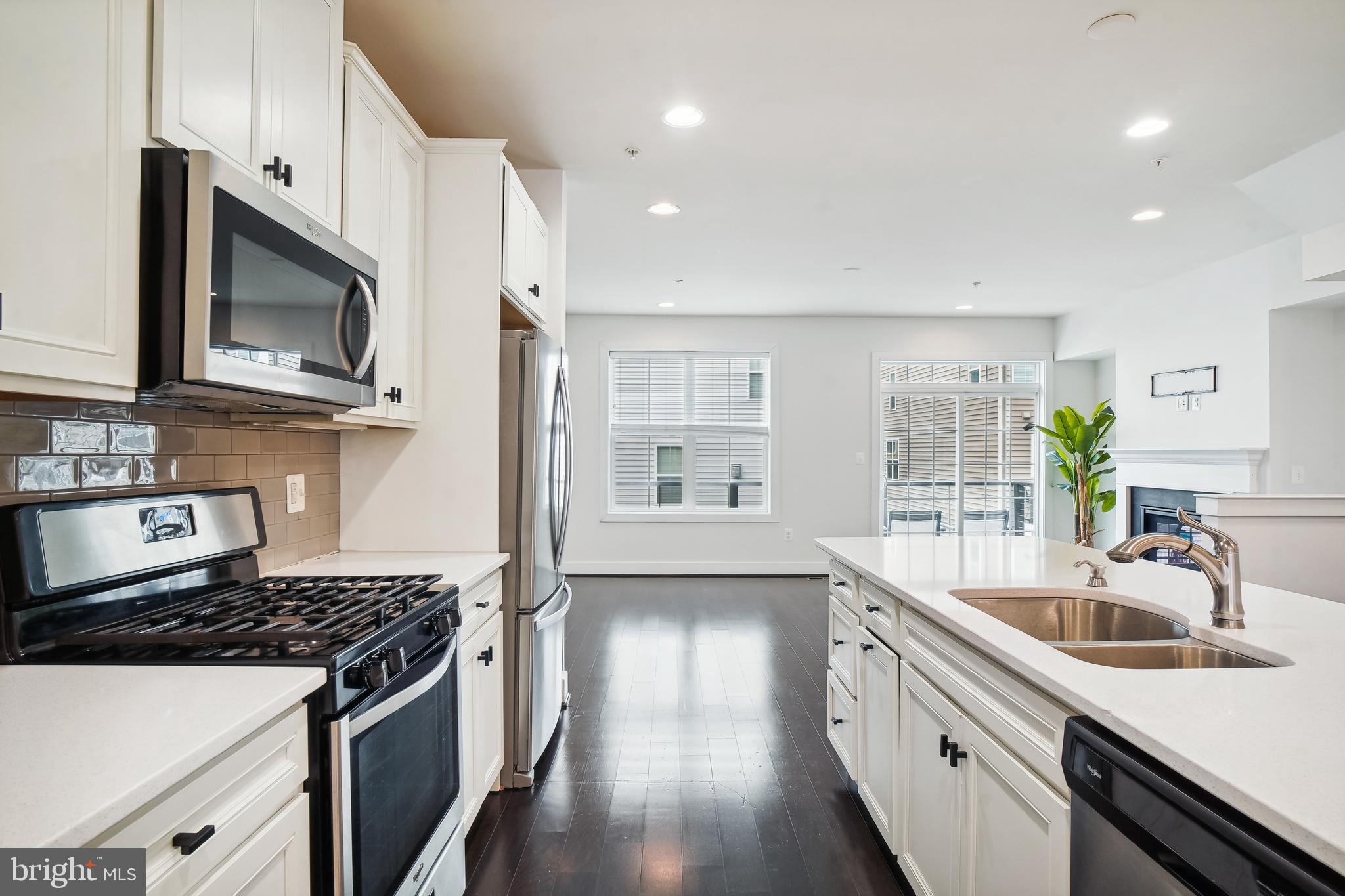 a kitchen with stainless steel appliances granite countertop a sink stove and cabinets