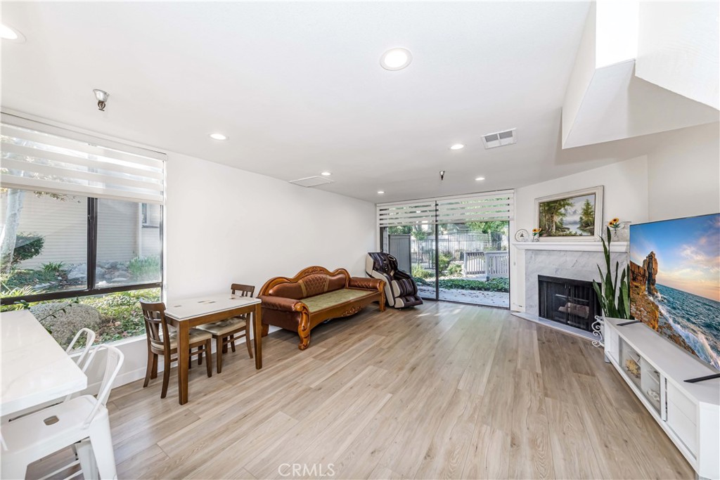 a living room with furniture a fireplace a flat screen tv and a large window