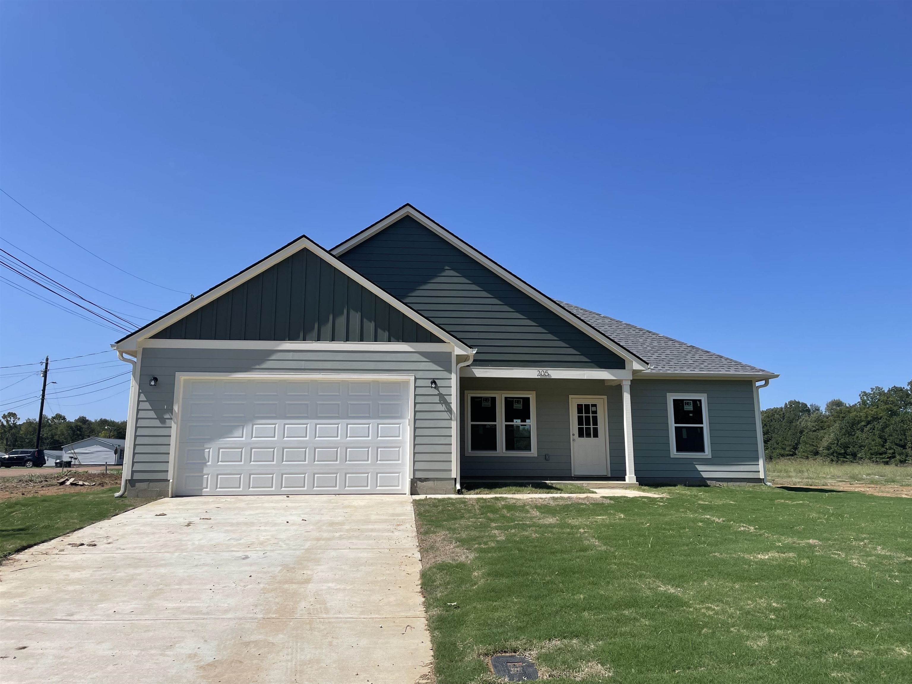 View of front facade featuring a garage and a front yard