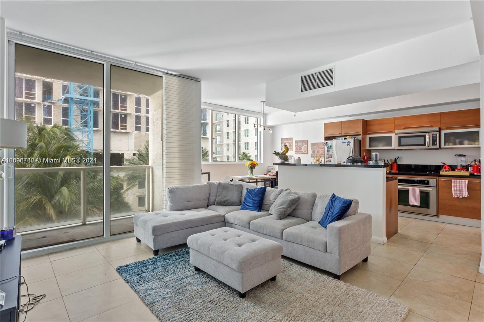 a living room with furniture and a floor to ceiling window