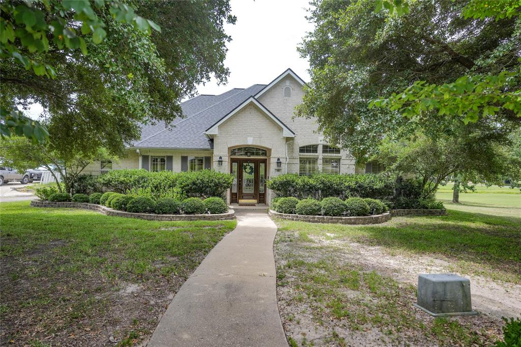 a front view of a house with a yard and trees