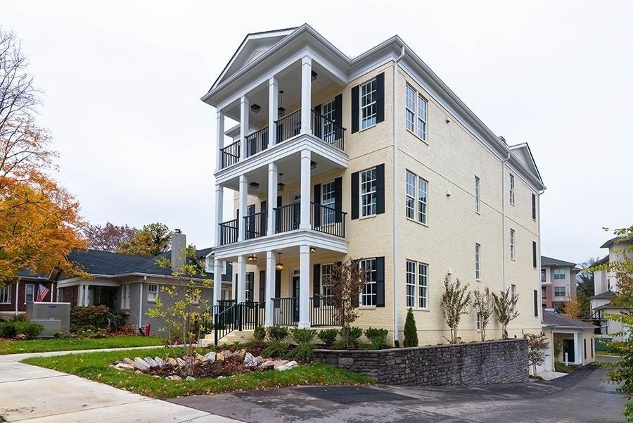 a front view of a residential apartment building with a yard