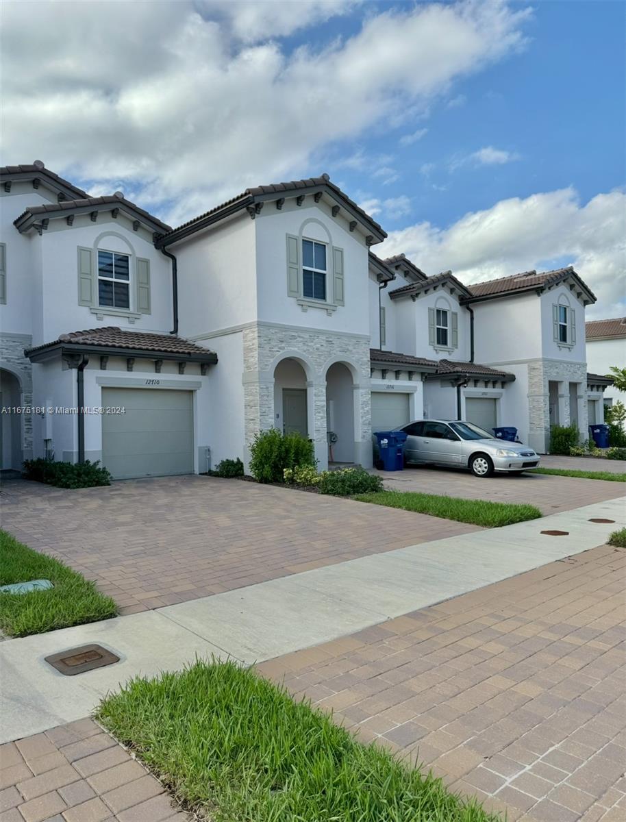 a front view of a house with a yard and garage