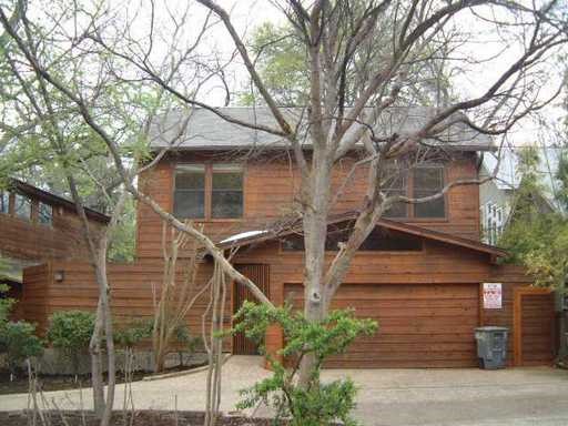 a front view of a house with a tree