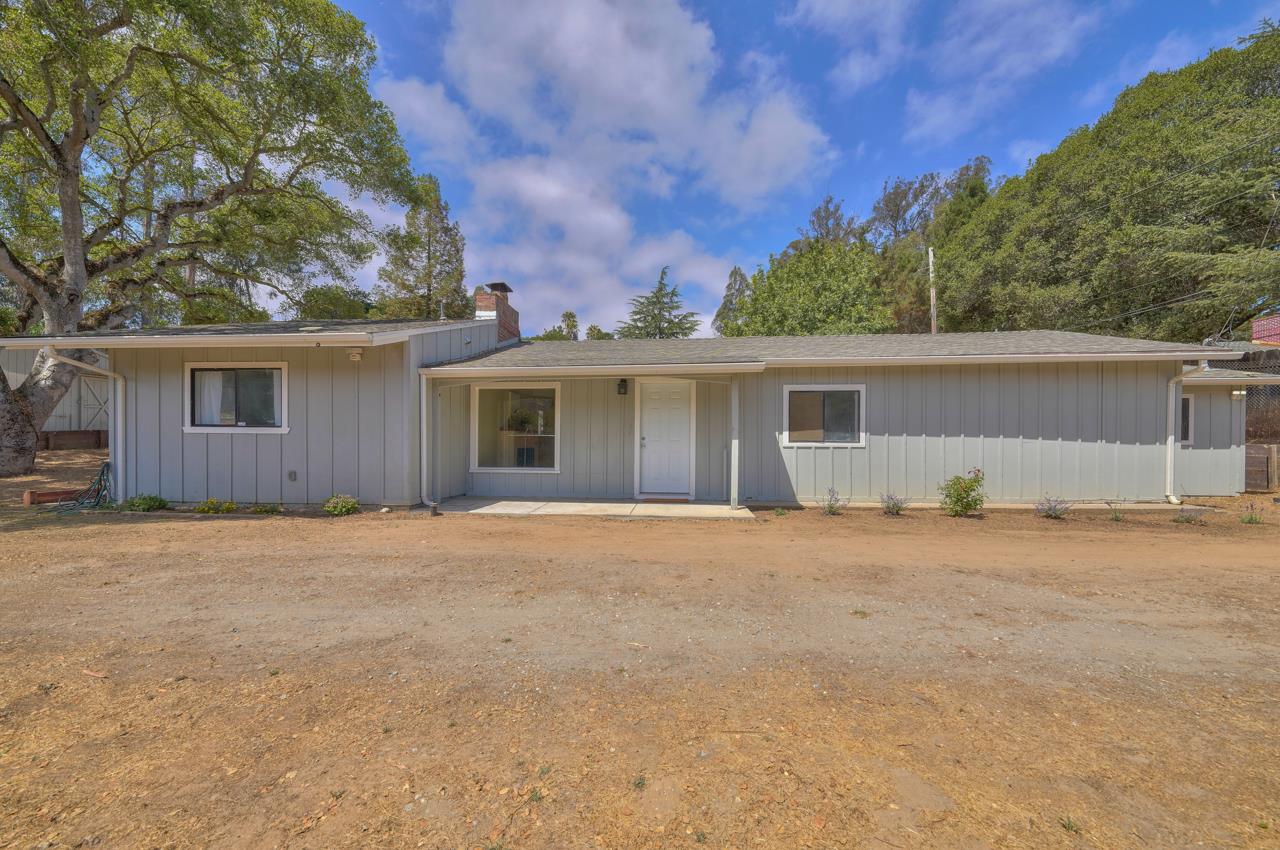 front view of house with a yard and trees