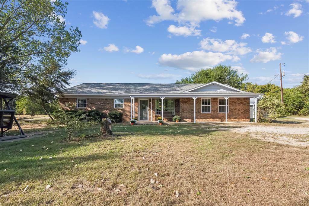 a front view of house with outdoor seating and green space