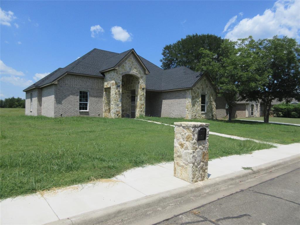 a view of a house with a yard and large tree