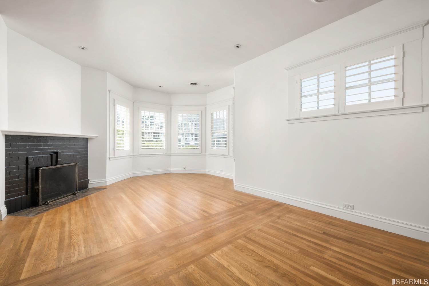 a view of empty room with windows and fireplace