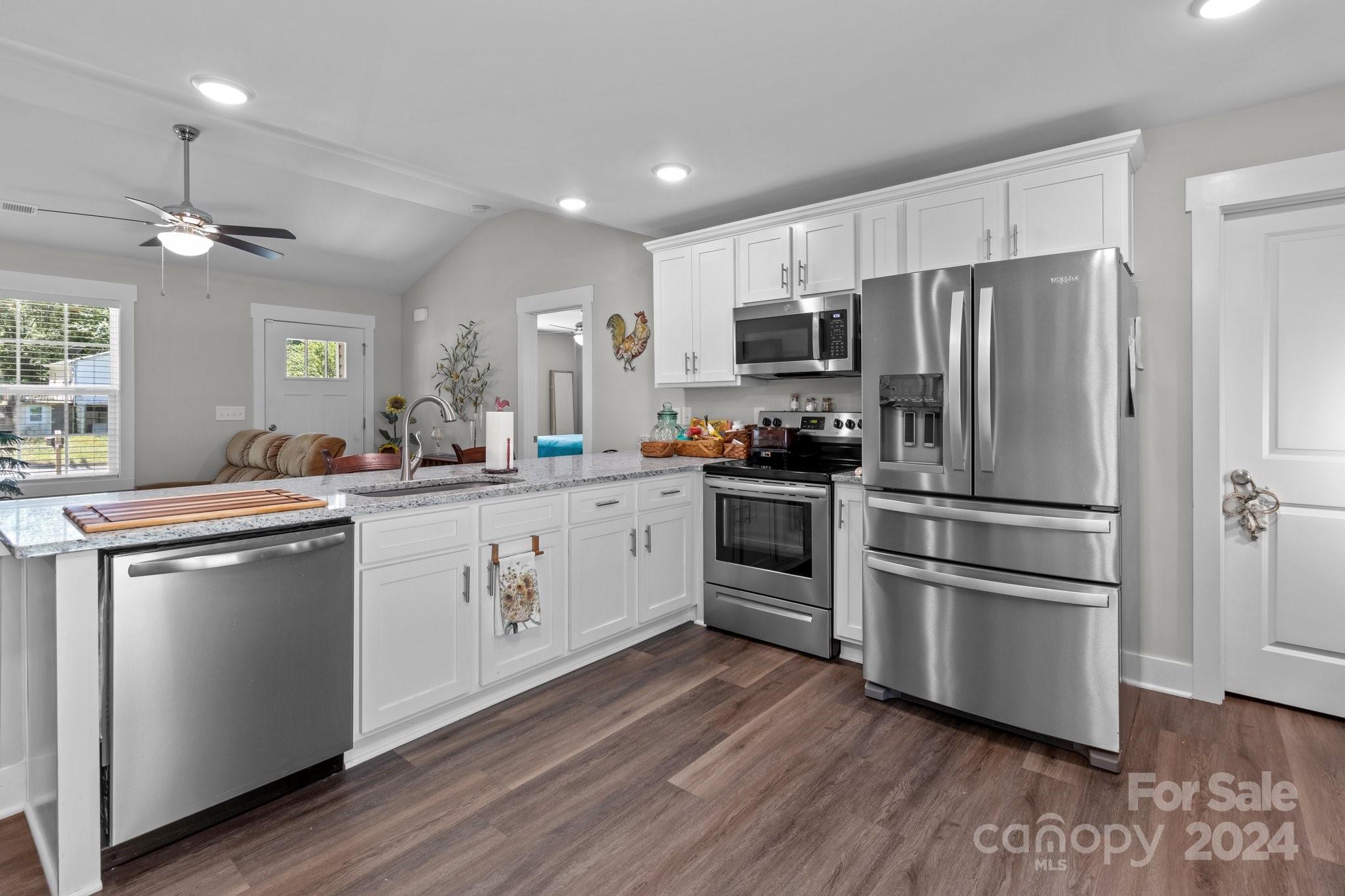 a kitchen with stainless steel appliances a refrigerator sink and microwave