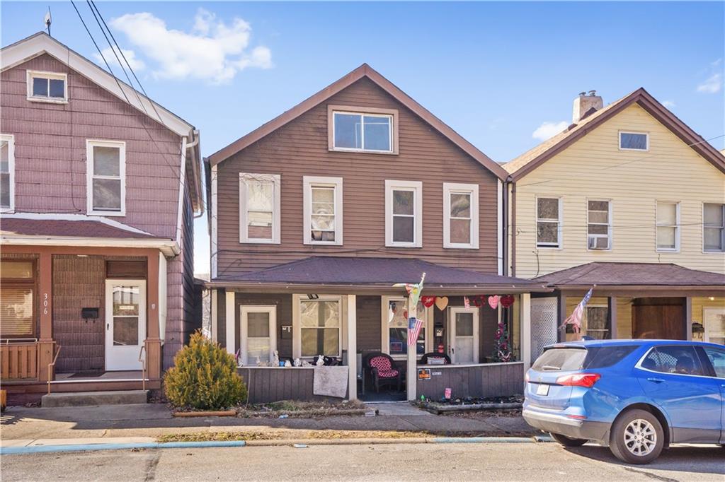 a front view of a residential apartment building with car parked