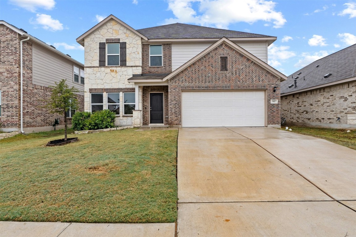 a front view of a house with a yard and garage