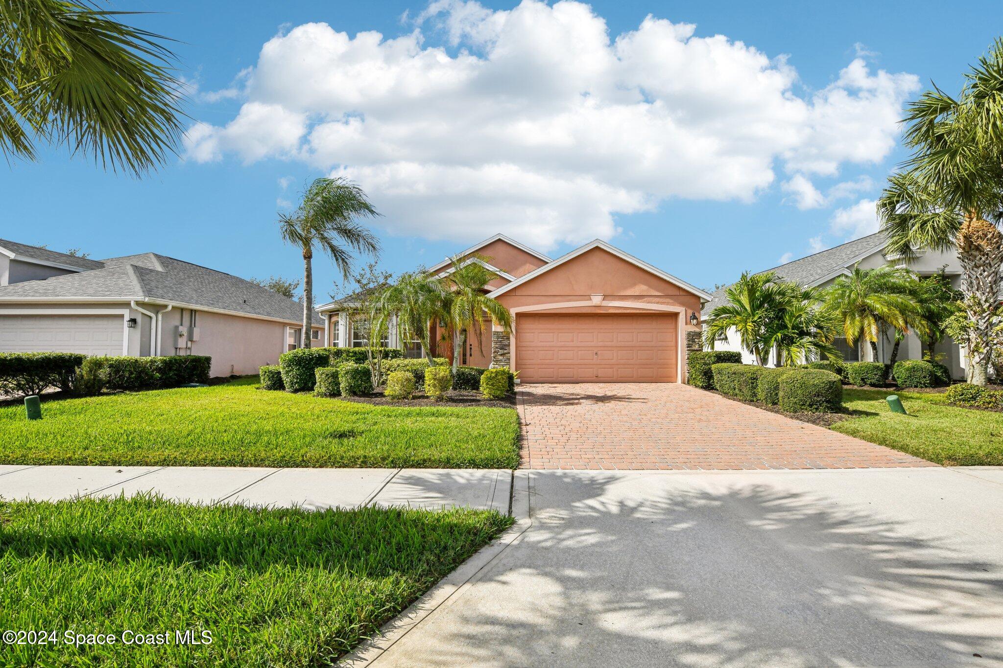 a front view of a house with a yard and garage