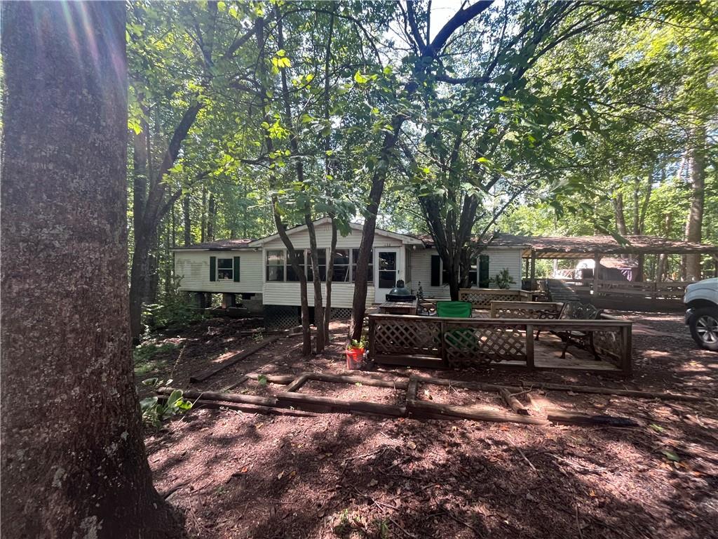 a view of a house with a yard tree and sitting area