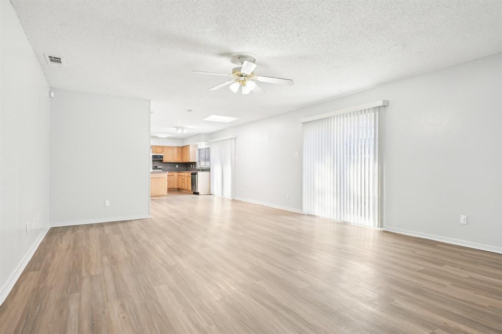 a view of a room with wooden floor and a ceiling fan