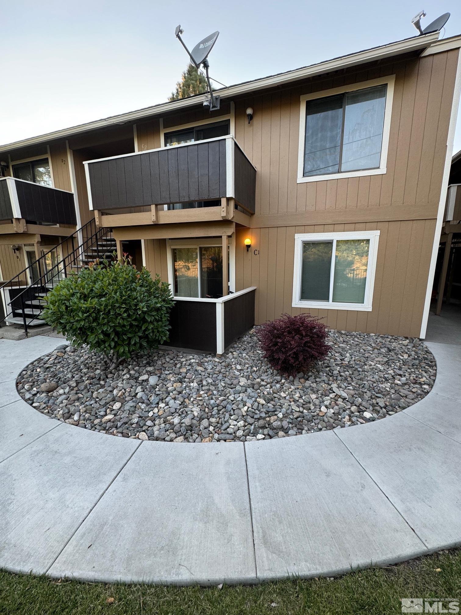 a front view of house with yard and trees in the background