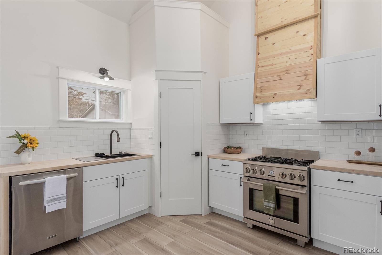 a kitchen with white cabinets stainless steel appliances and sink