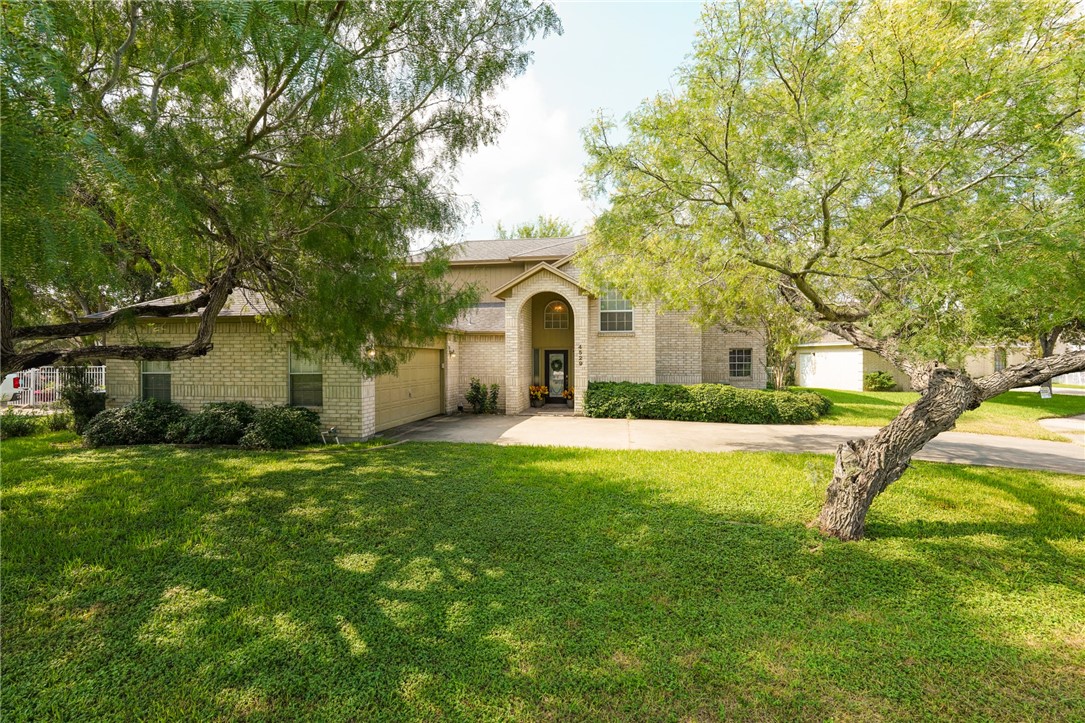 a front view of a house with yard and green space