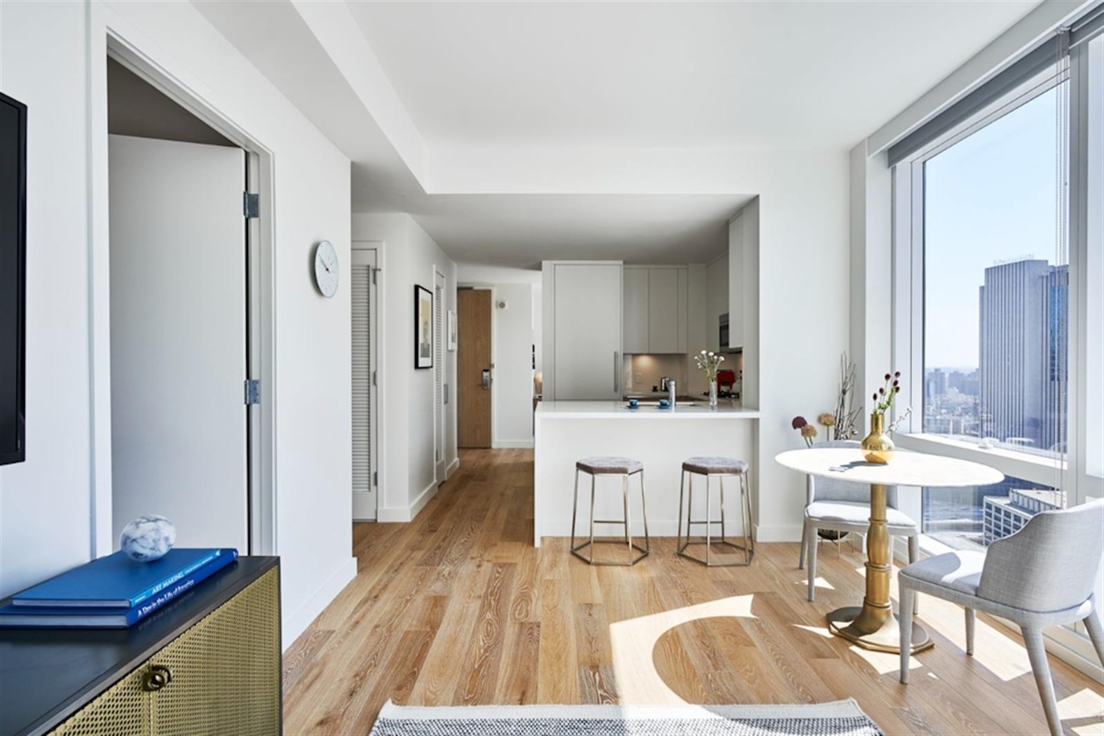 a living room with stainless steel appliances kitchen island granite countertop furniture and a wooden floor