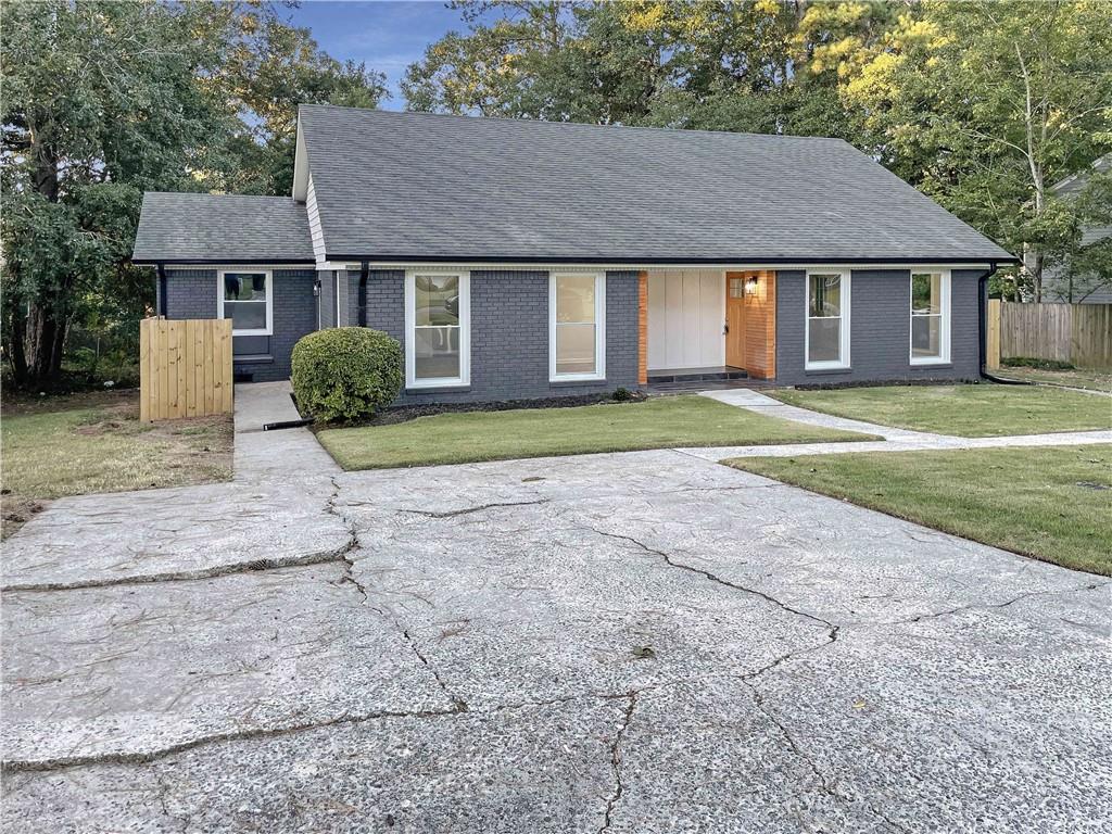 a view of a house with a yard and large tree