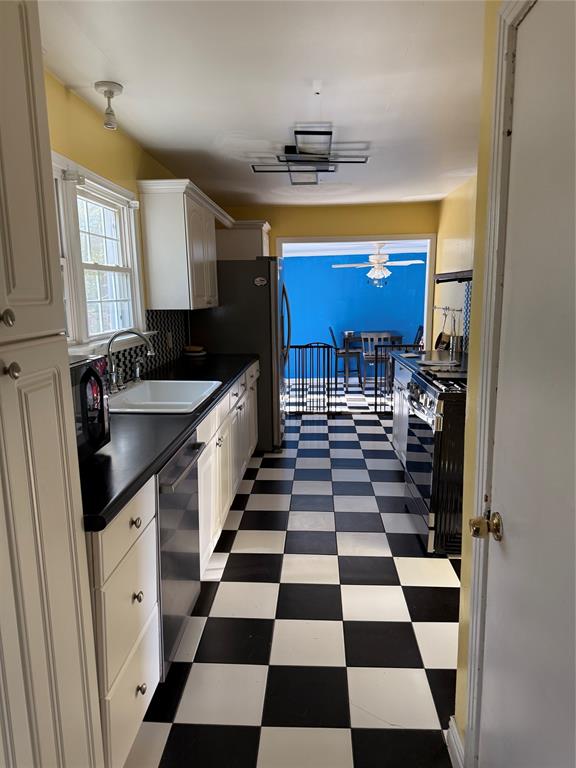 a kitchen with a checkered floor and white cabinets