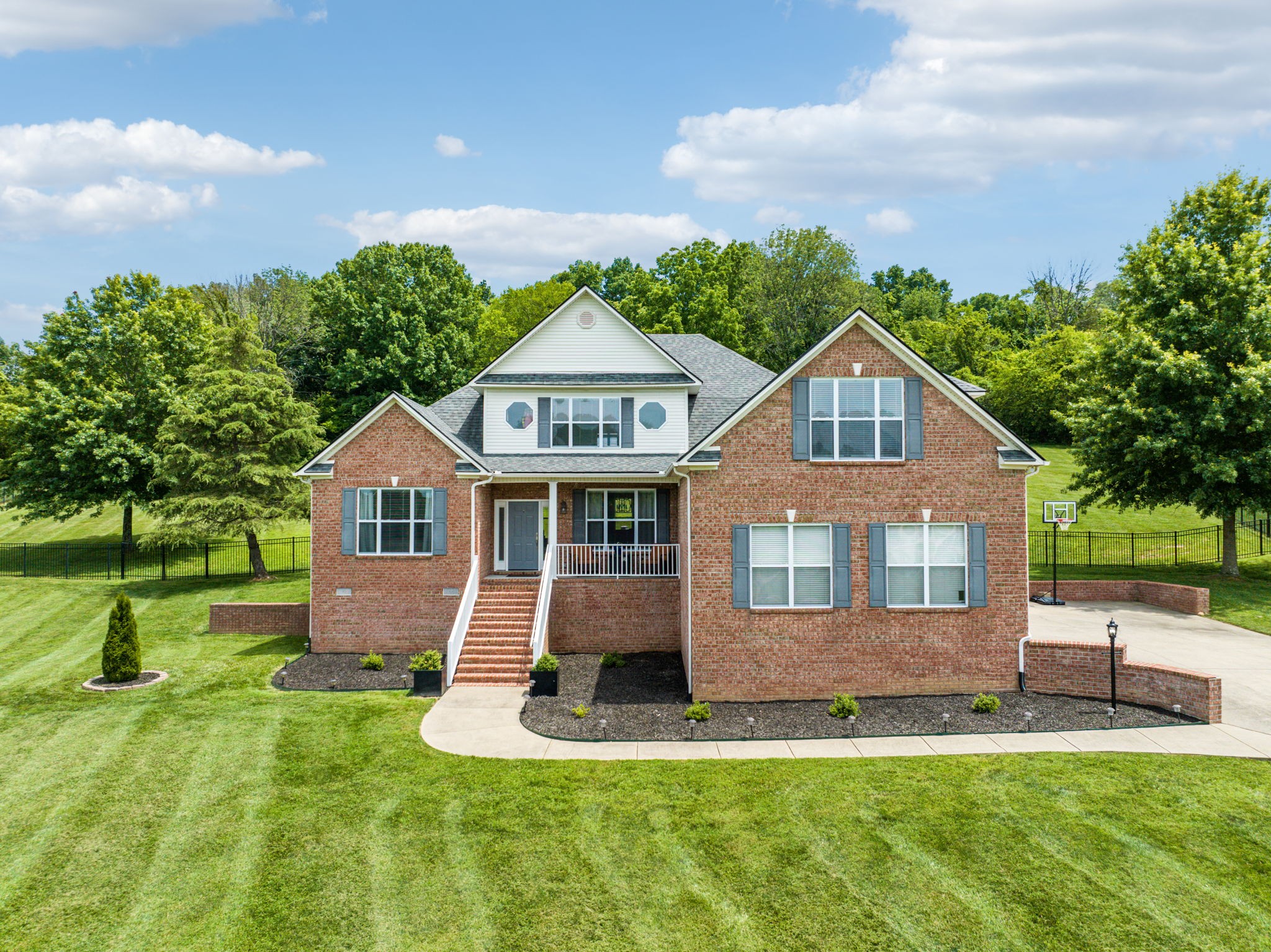 a front view of a house with a yard and green space