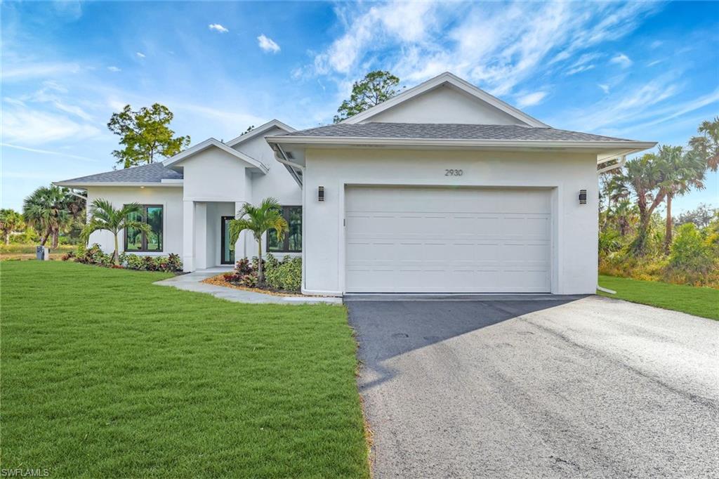 View of front of house featuring a front yard and a garage