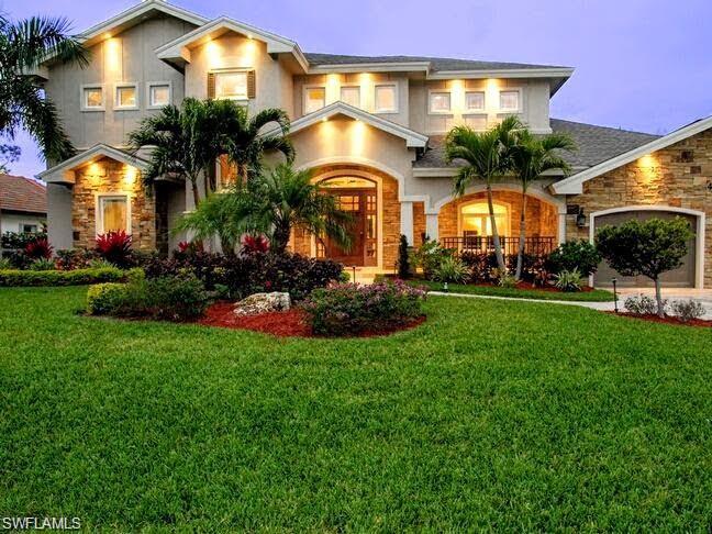 View of front facade with a yard and a garage