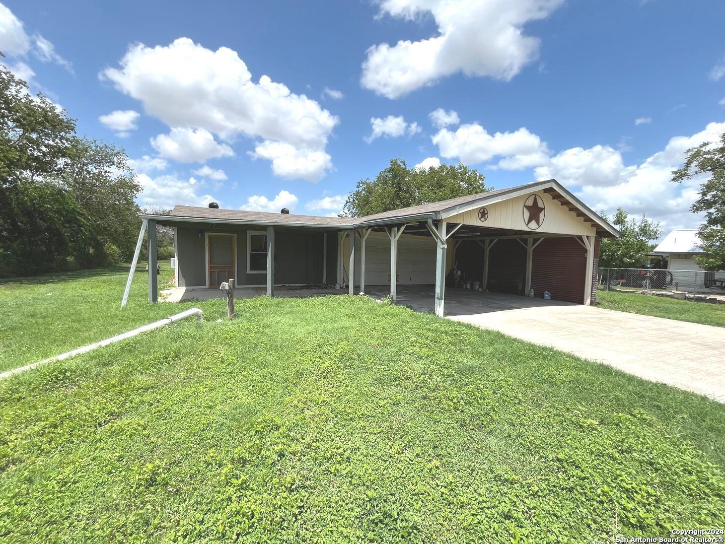 a view of a house with a yard and pathway