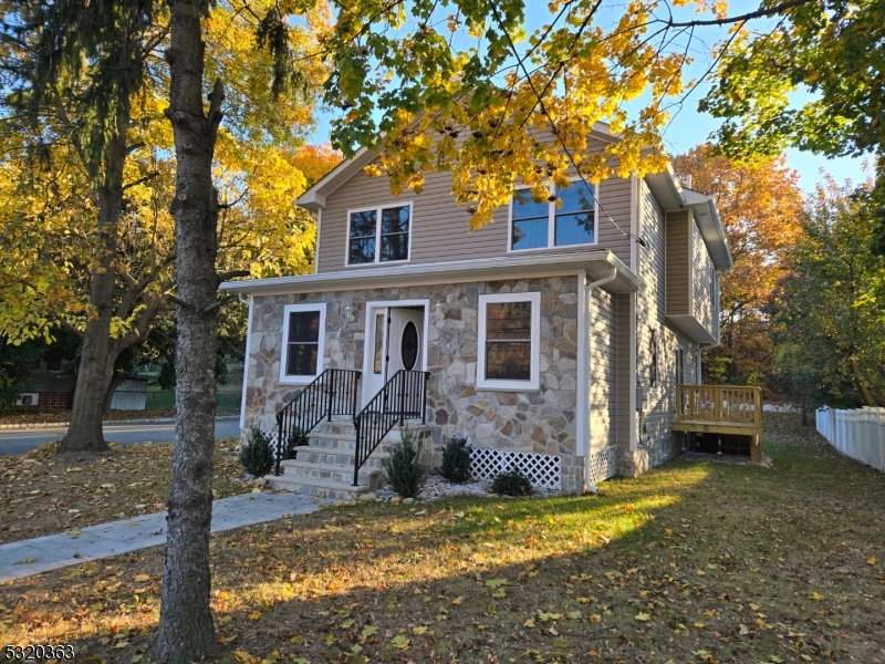 a view of a house with backyard and a tree