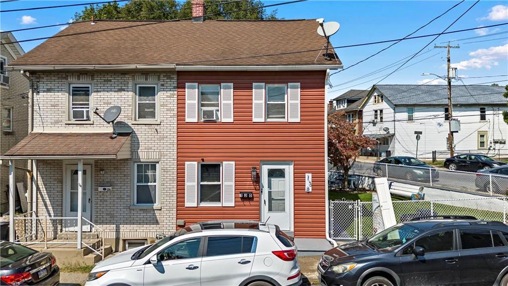 a front view of a house with cars parked