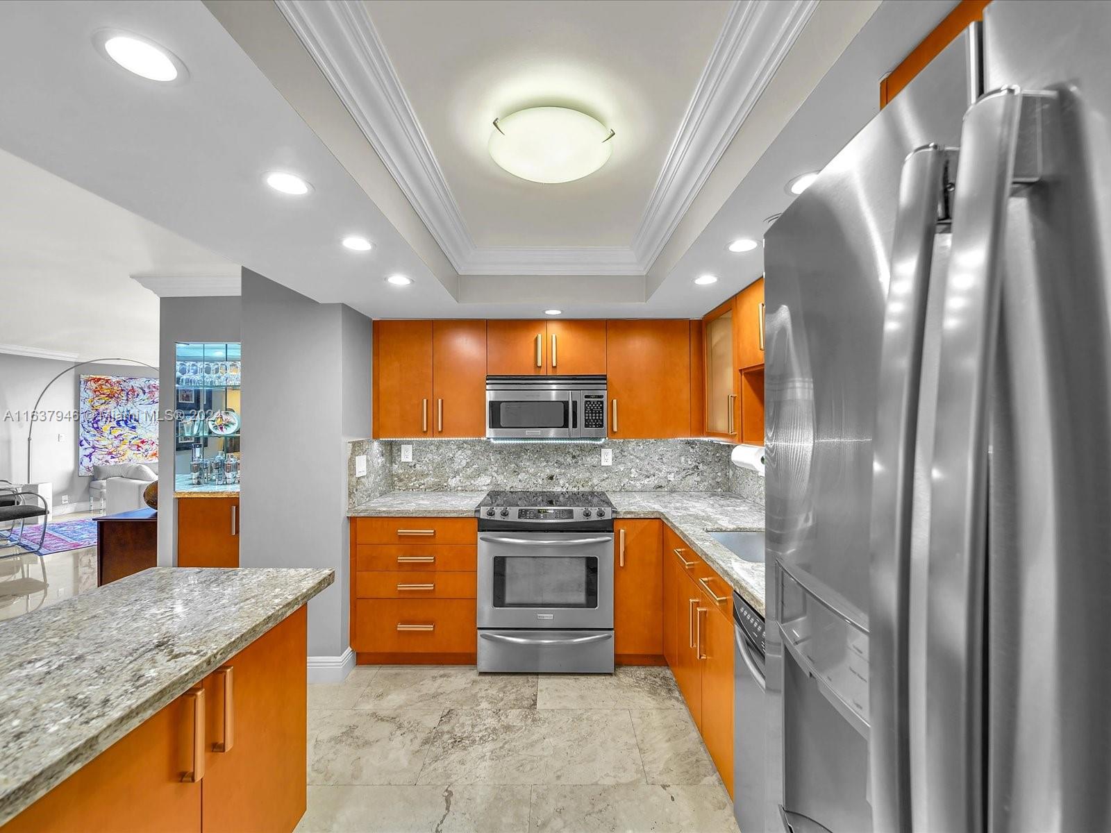 a kitchen with stainless steel appliances granite countertop sink stove and refrigerator