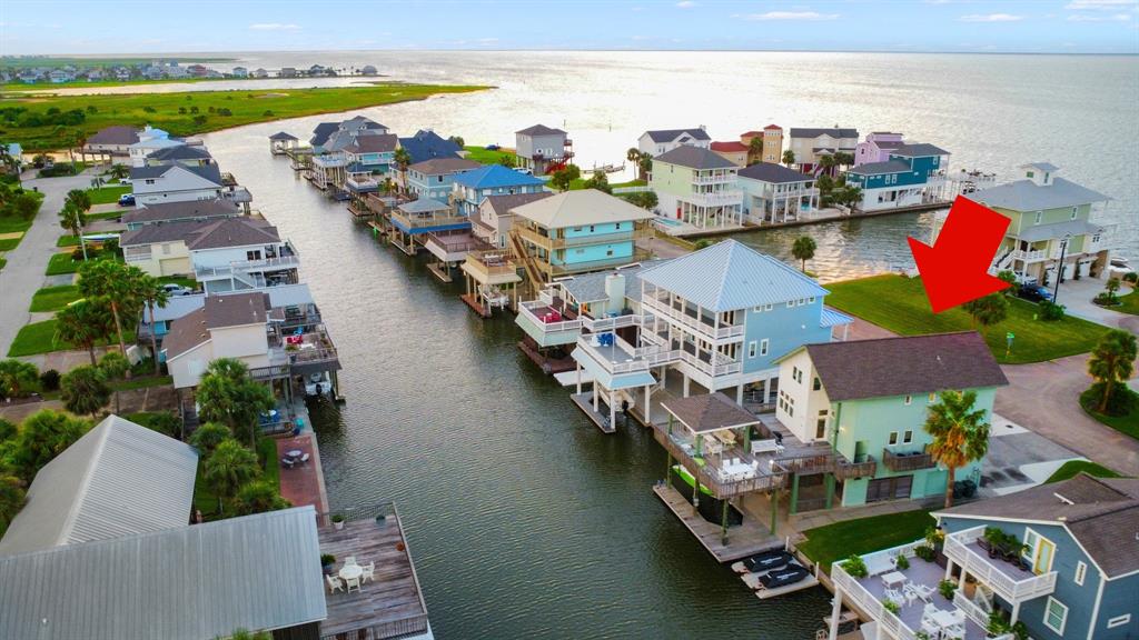 an aerial view of residential houses with outdoor space and ocean view