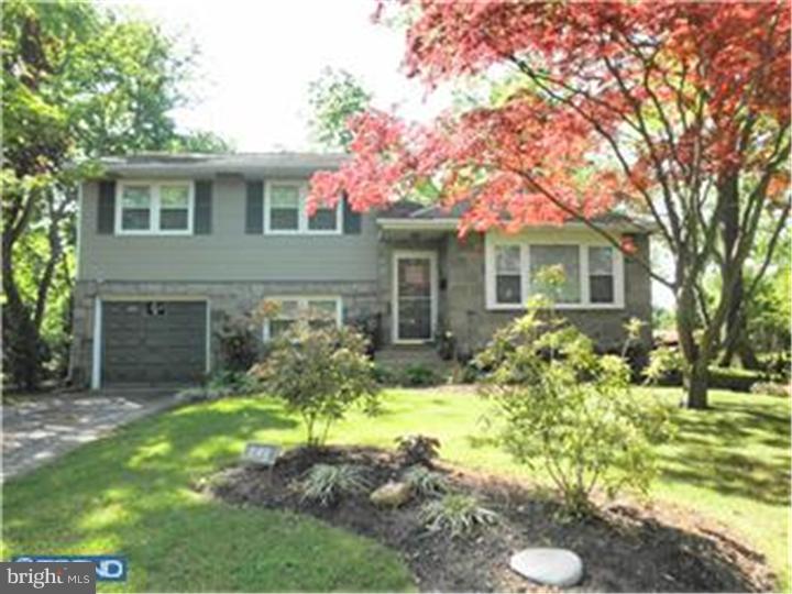 a front view of house with yard and trees around