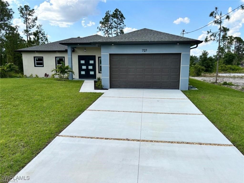 a front view of a house with a yard and garage