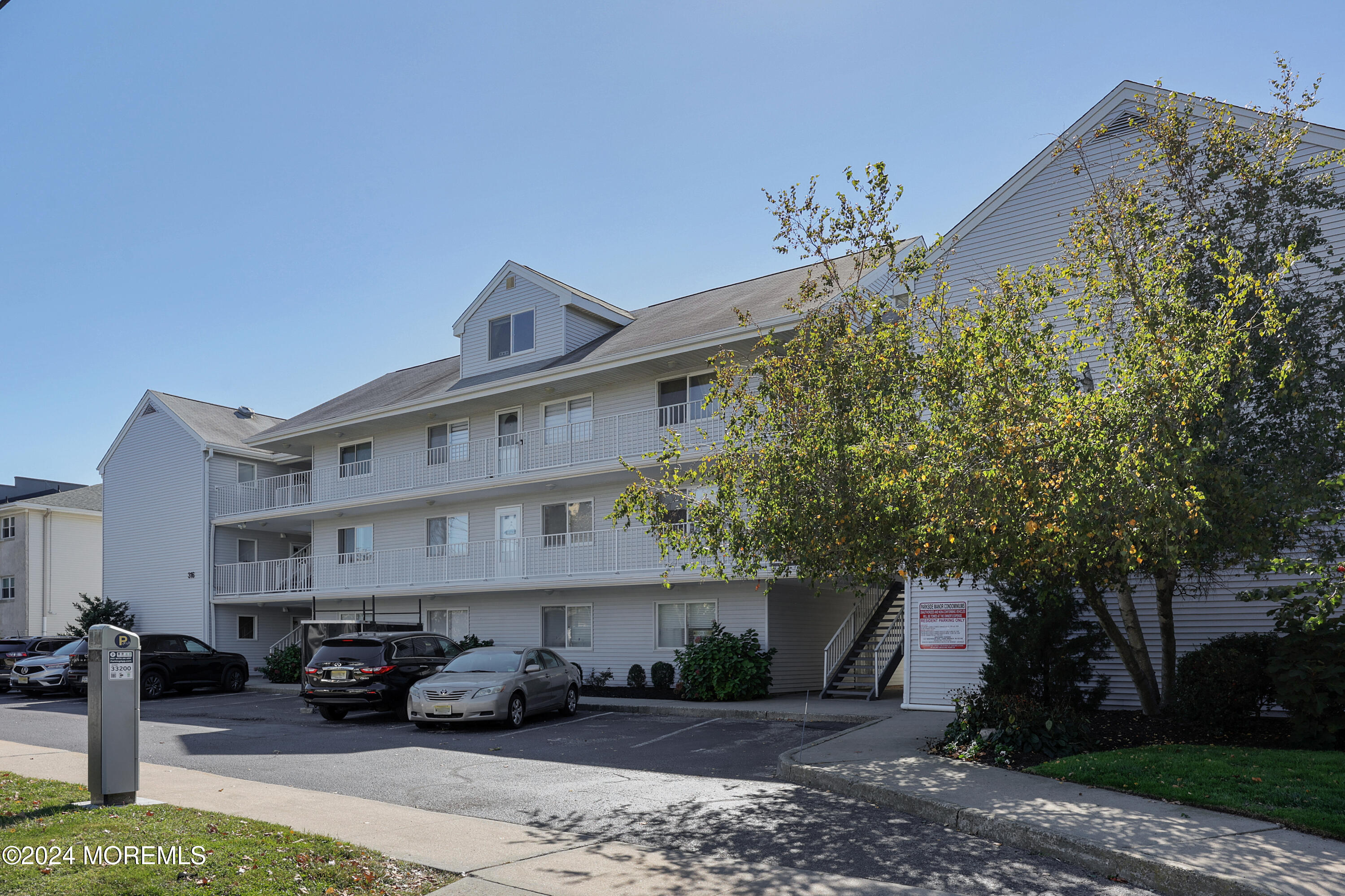 a front view of a building with outdoor space and trees