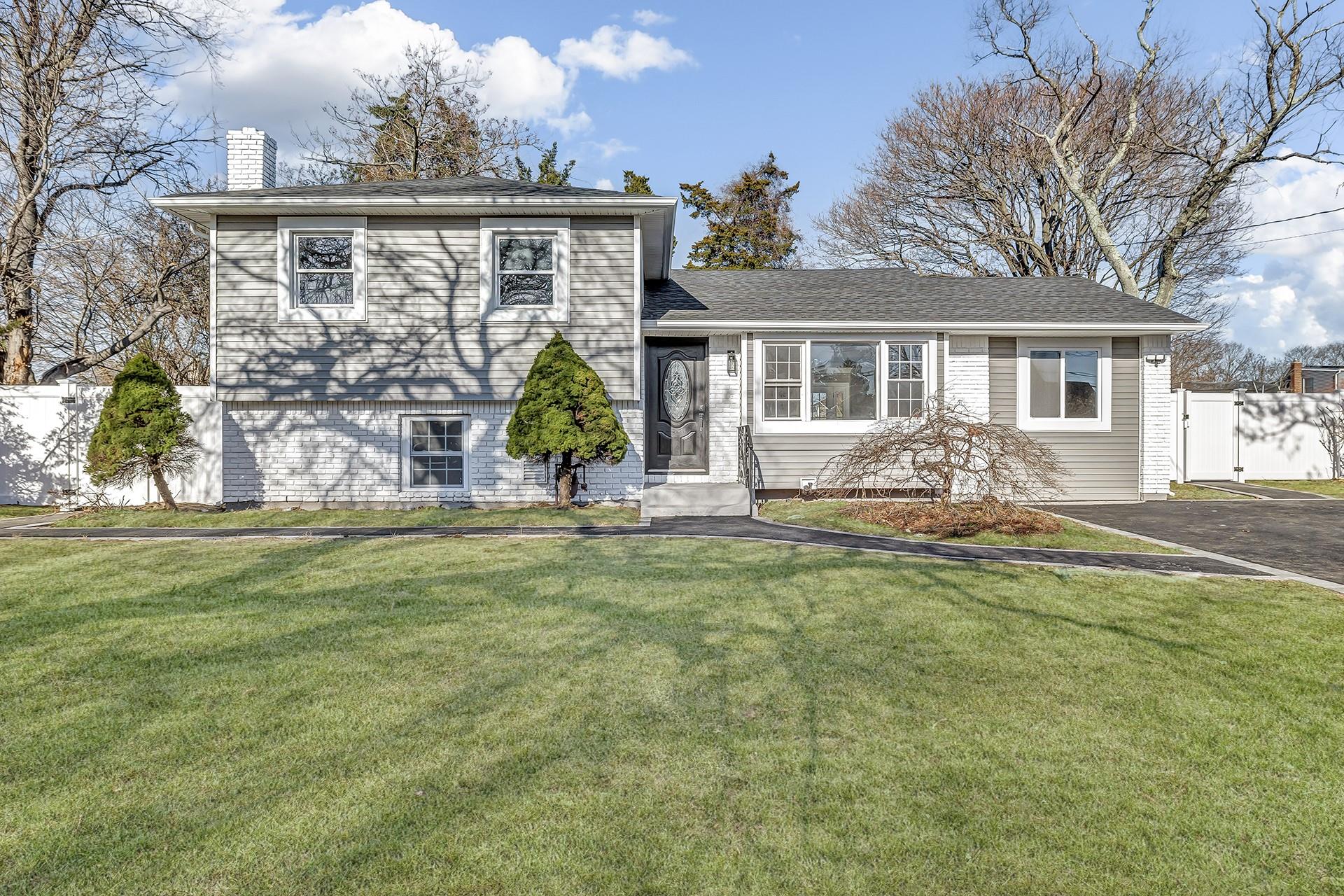 Tri-level home featuring a front lawn