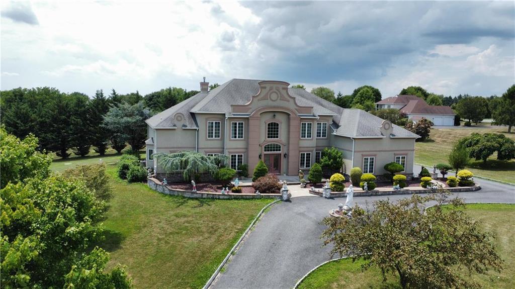 a front view of a house with a garden and lake view