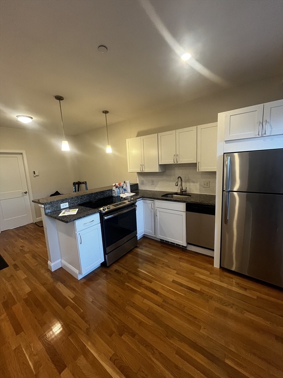 a large kitchen with stainless steel appliances granite countertop a stove a sink dishwasher and a refrigerator