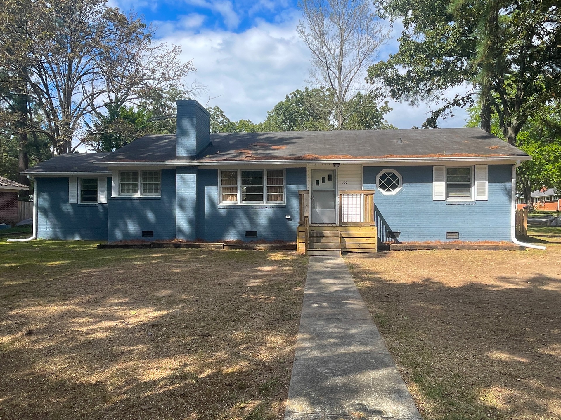 a view of a house with a yard and large tree