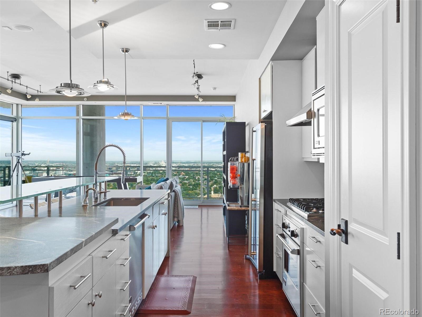 a kitchen with stainless steel appliances granite countertop a sink stove and refrigerator