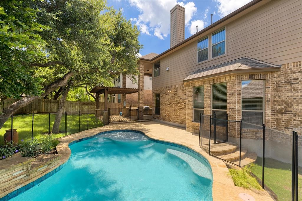 a backyard of a house with table and chairs under an umbrella