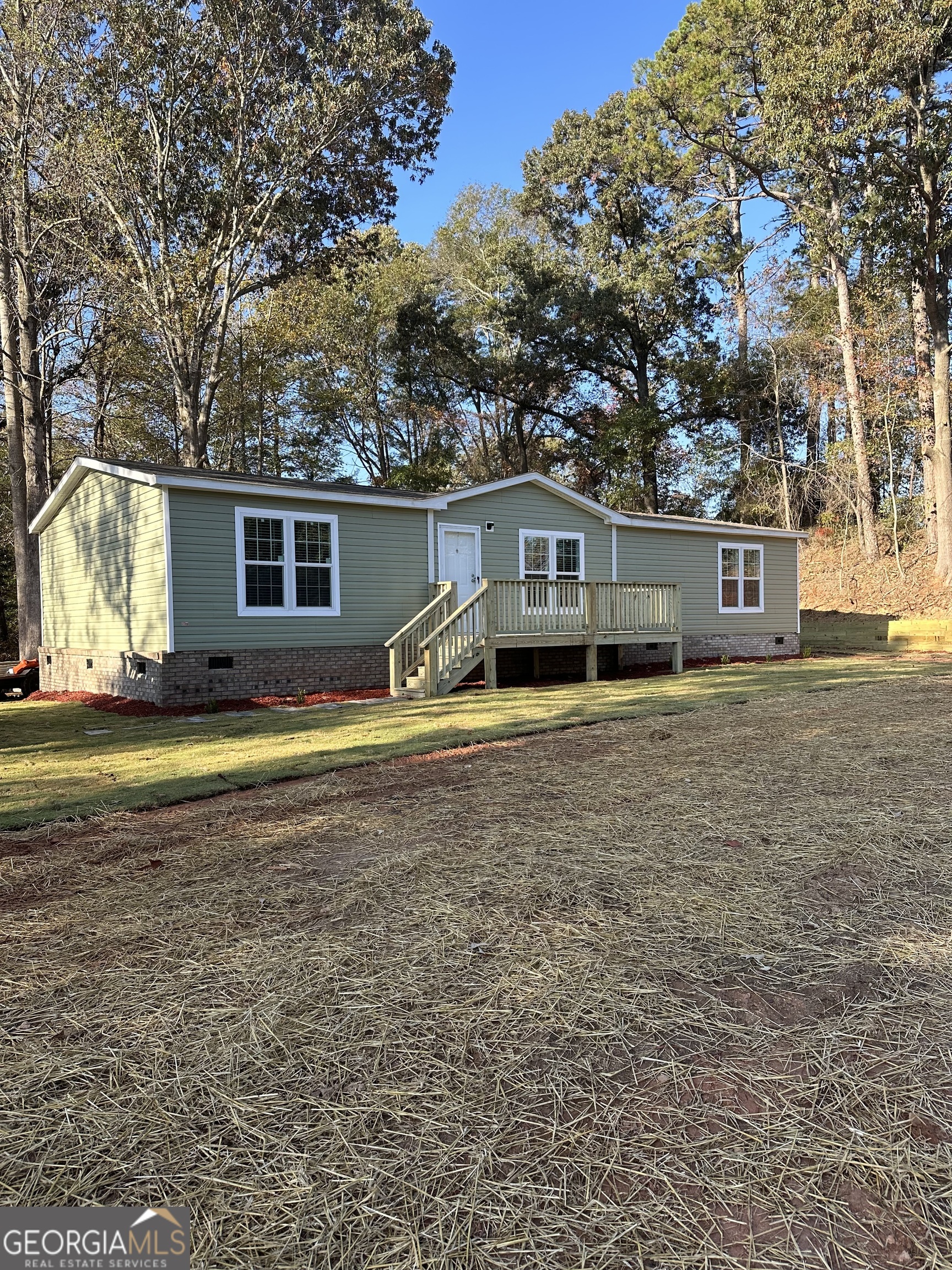 a view of house with a big yard and large trees