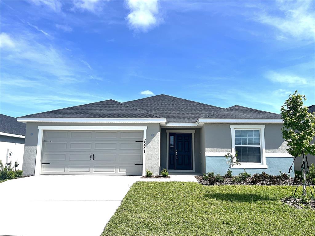 a front view of a house with a yard and garage