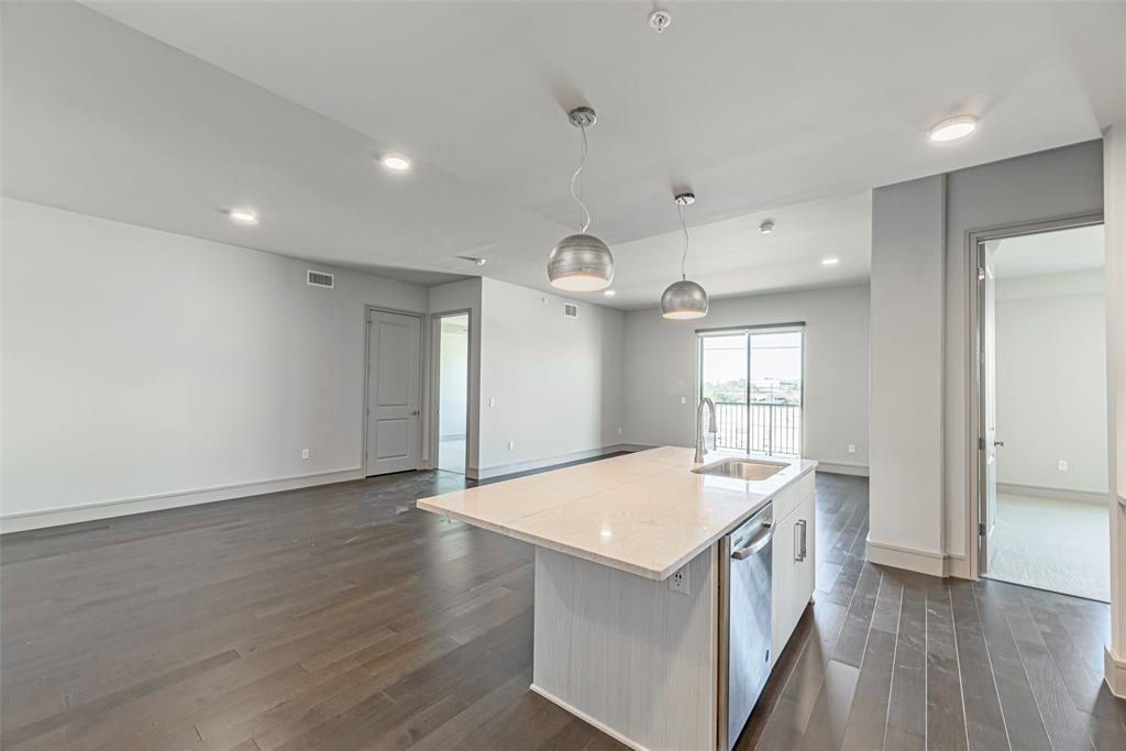 a kitchen with a sink a refrigerator and wooden floor