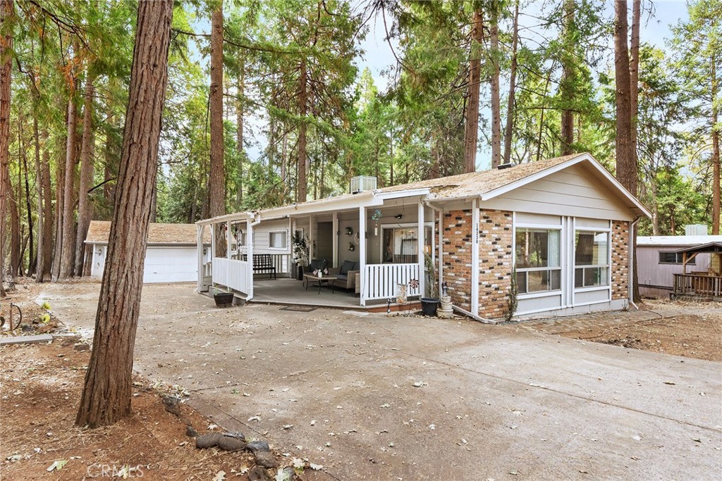 a view of a house with a yard and large trees