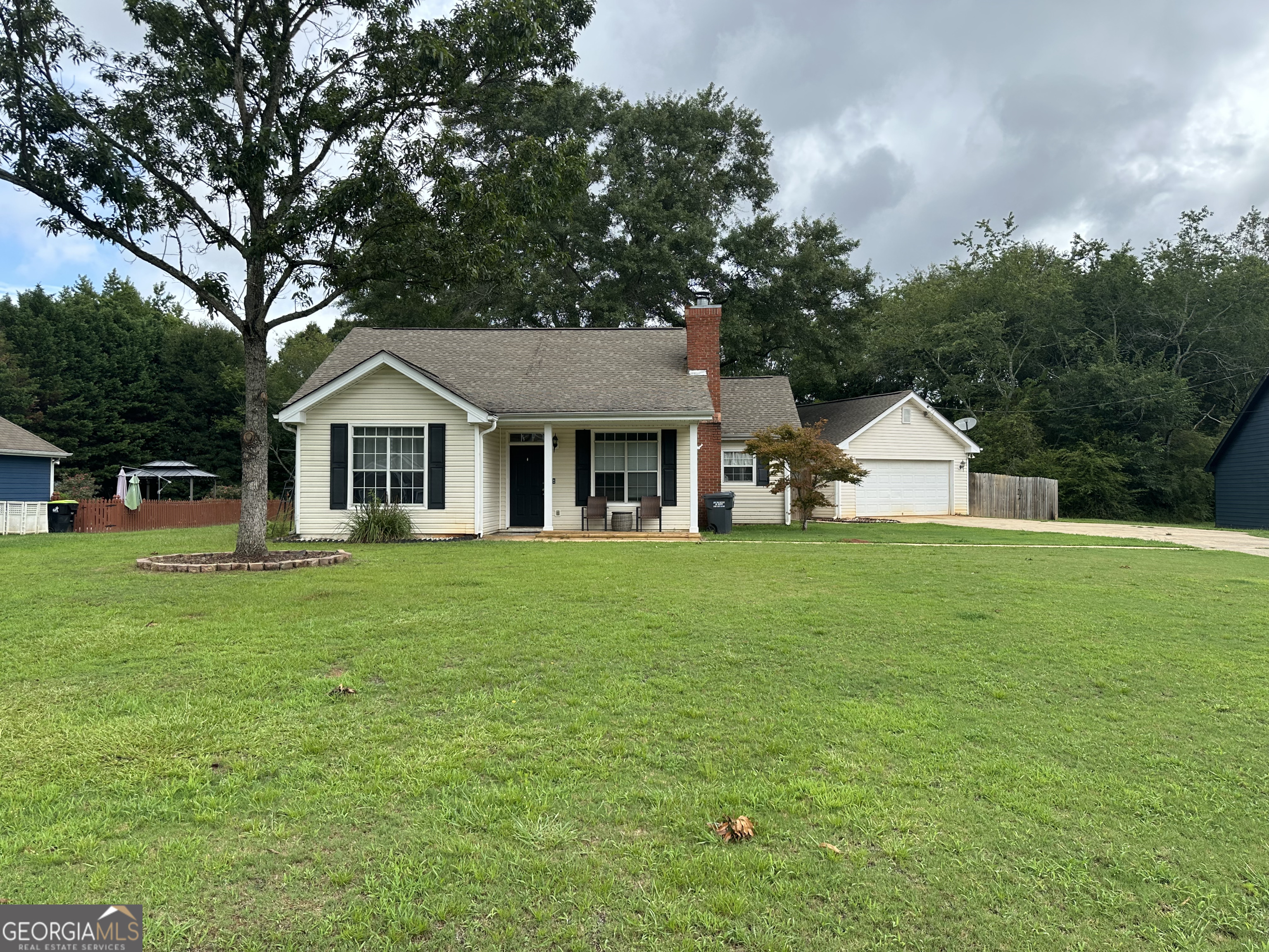 a front view of a house with a yard and trees