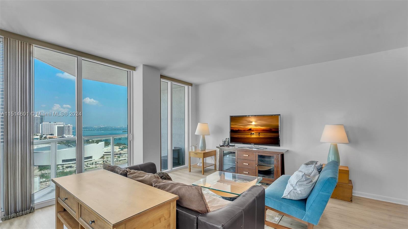 a living room with furniture a flat screen tv and a large window